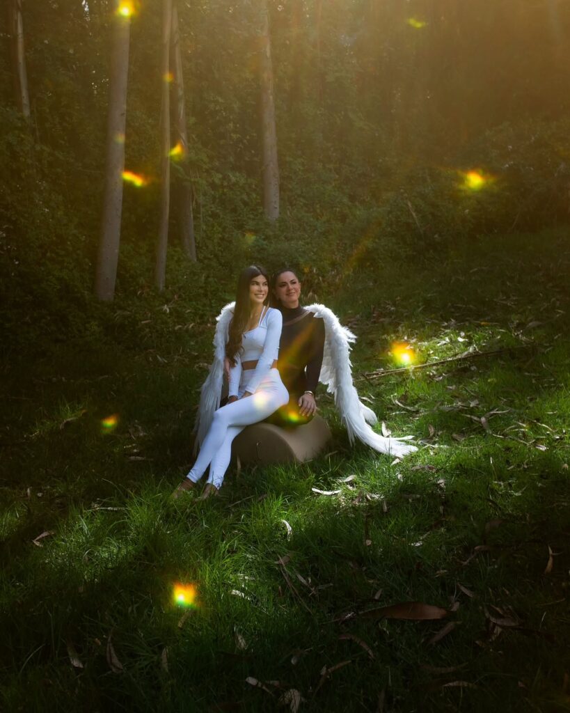 In einem Wald sitzendes Paar, umgeben von warmen goldenen Lichteffekten