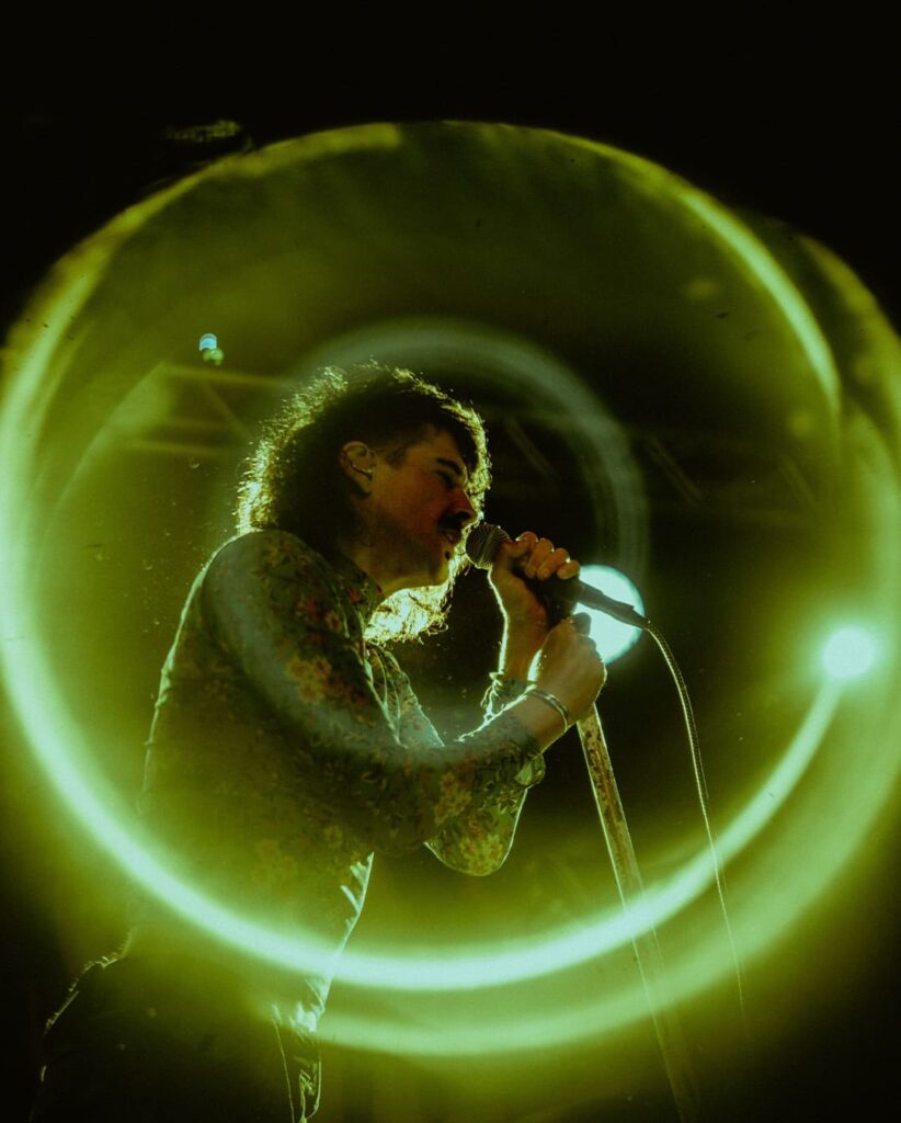 Live concert photograph using the SZ Filters Psyco Black Hole Filter, creating a large green circular effect around the singer