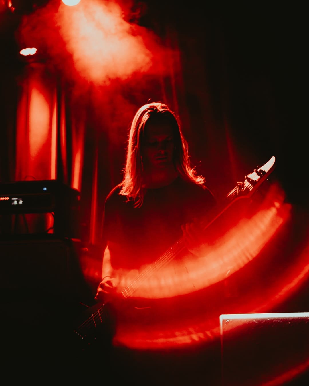 Live concert photograph using an SZ Filters Aura Filter with red circular light effects around the musician