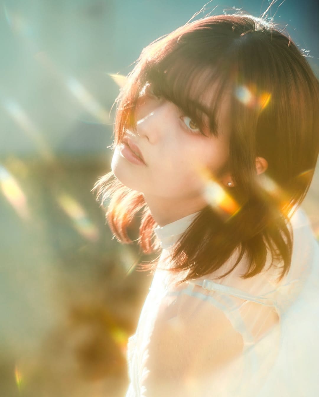 Portrait doux avec un flare naturel et des reflets oniriques créés par l’expérimentation de la lumière dans l’appareil