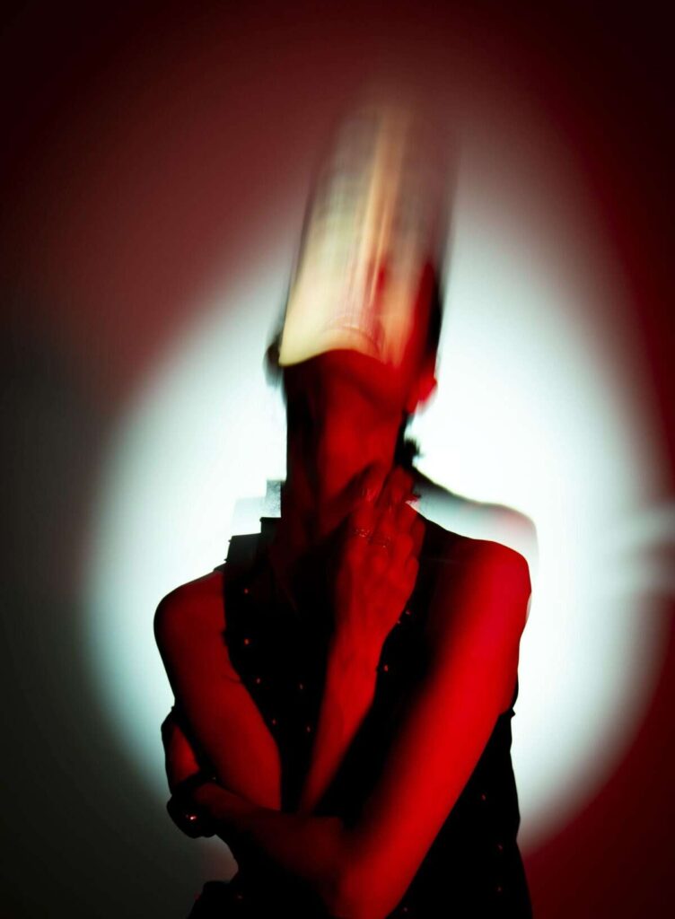 Portrait éclairé en rouge avec des traînées de mouvement verticales créées par le filtre Liner V2